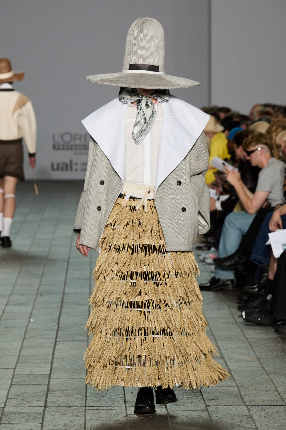 Model wearing a huge hat and straw skirt