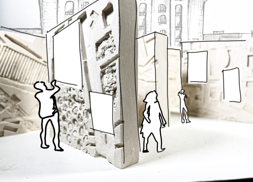 A small-scale architectural model of a conceptual museum. The digital structure is made from layered materials such as foam board, plaster, carved textures, and embedded fragments, giving the walls a rough, tactile quality. One central wall panel appears split or sectioned to reveal different material treatments—smooth surfaces, recessed cavities filled with crumpled or organic-looking material, and a lower portion embedded with rounded, pebble-like forms.  Blank rectangular panels are mounted on the walls, suggesting spaces for artworks or digital displays. The layout creates narrow passageways between freestanding walls, encouraging movement through the space.  Black outline drawings of human figures are superimposed. The CSM Facade is drawn in the background and other architectural motifs.