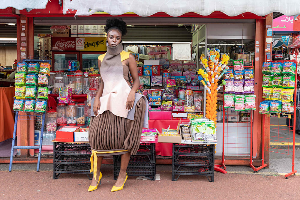 Fashion model wearing garment created by student outside at market