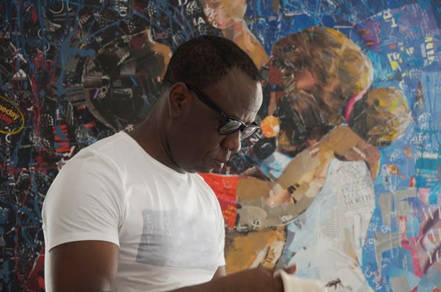 Rom Isichei in front of one of his pieces