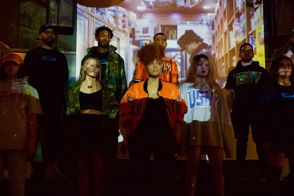 a diverse group of people standing in front of a projected image