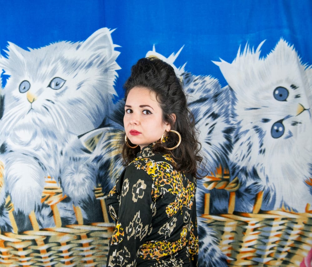 woman standing in front of a kitten blanket