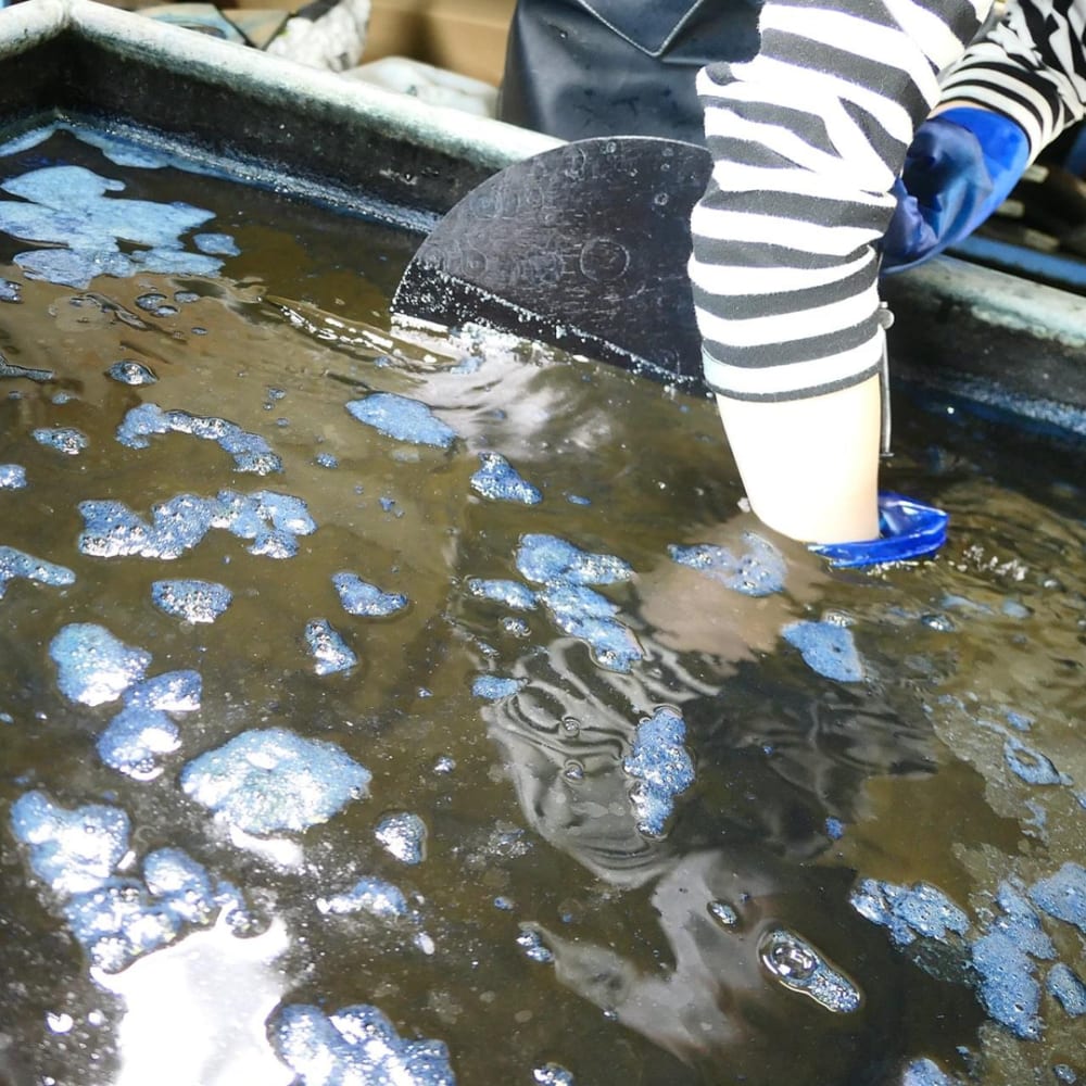 This is an image of the process of dyeing the fabric with the indigo liquid.