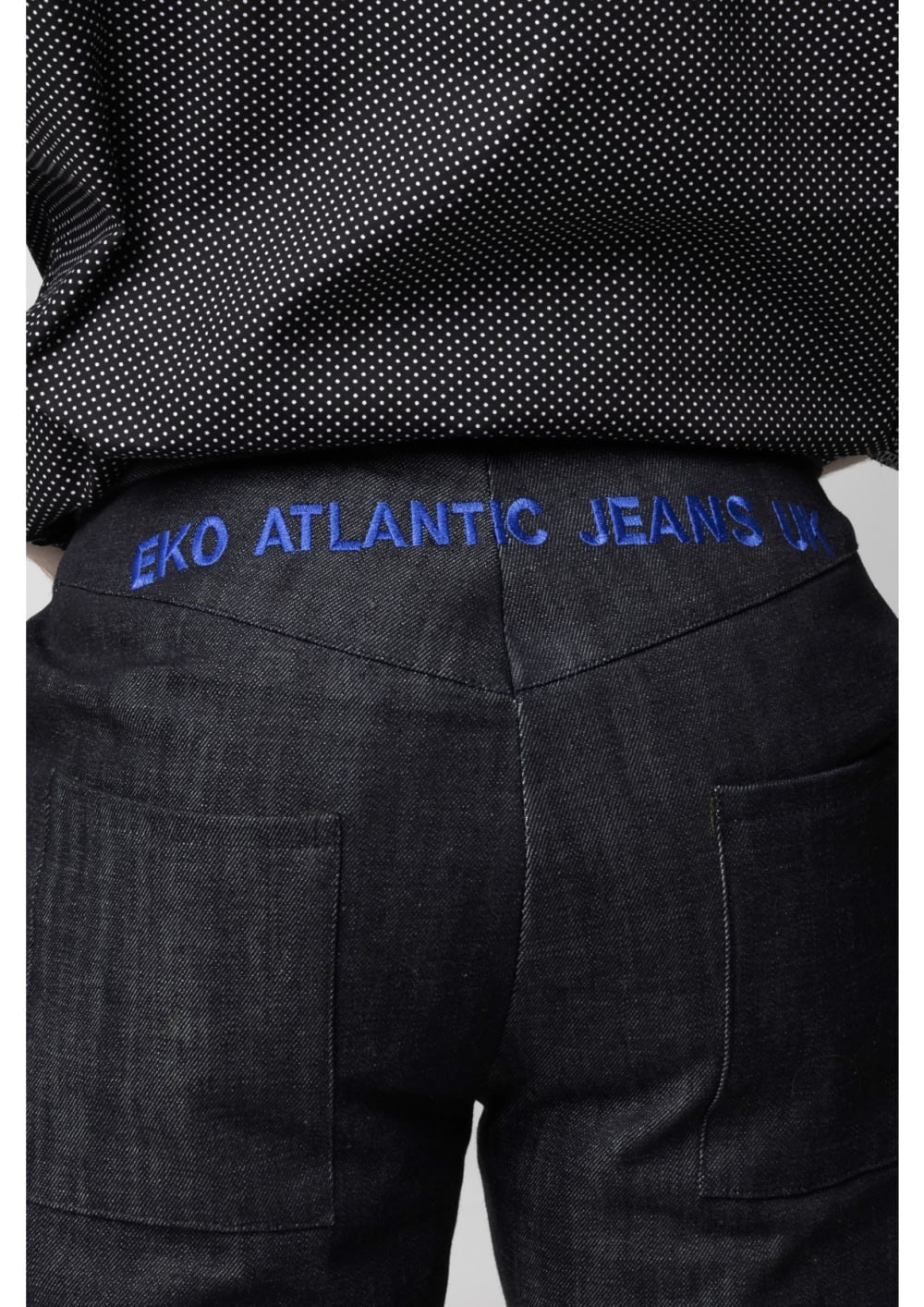 Photo of a person from behind, wearing double dark denim with 'Eko Atlantic Jeans UK' embroidered across the top of the jeans