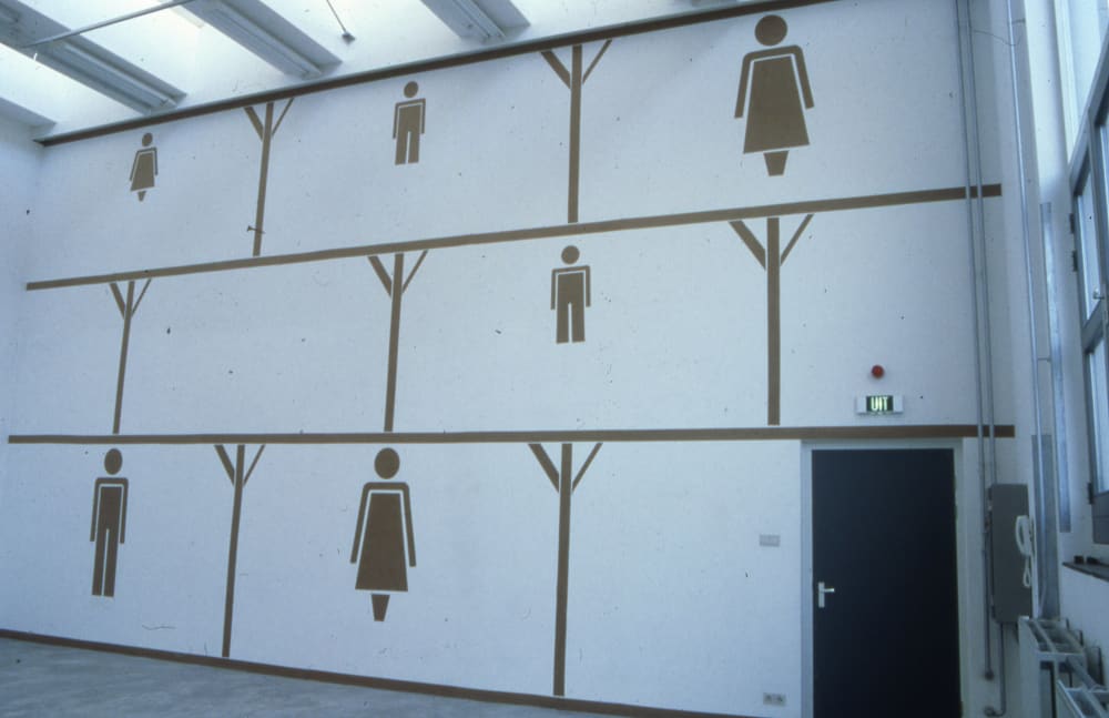 A large white room with cut-outs of people on the wall. 