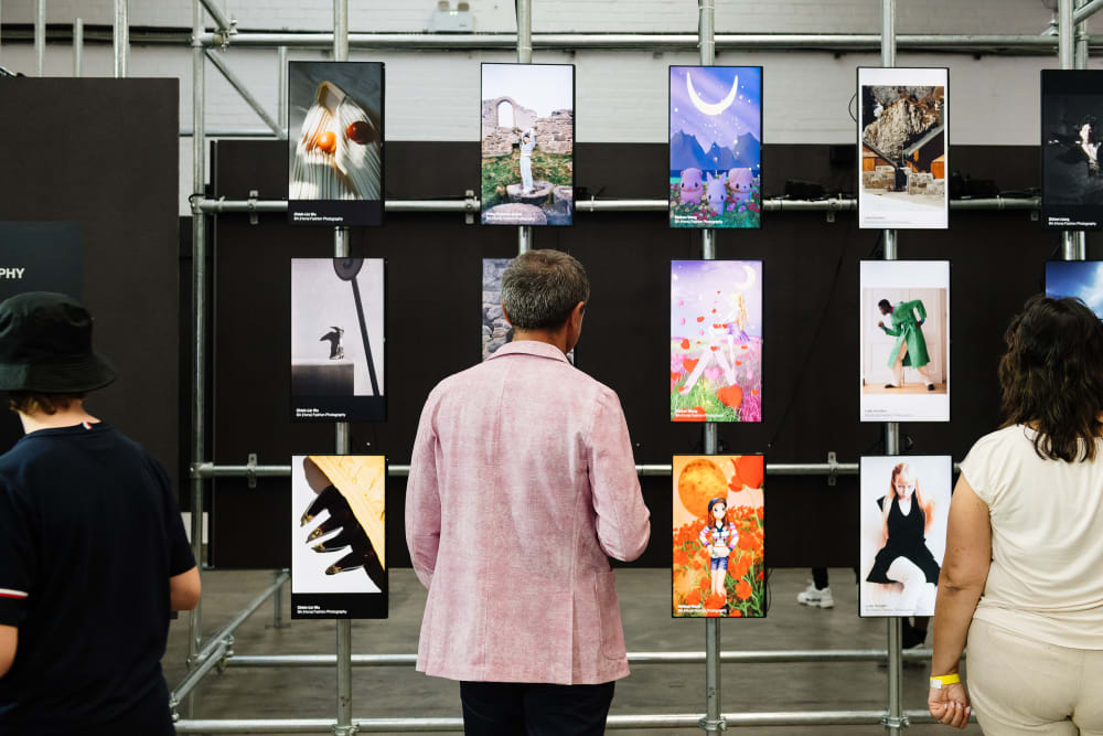 People looking at student work on digital panels