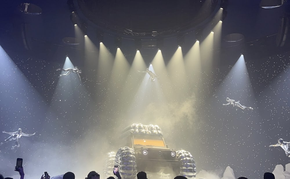 Jeep surrounded by people floating in the spaces