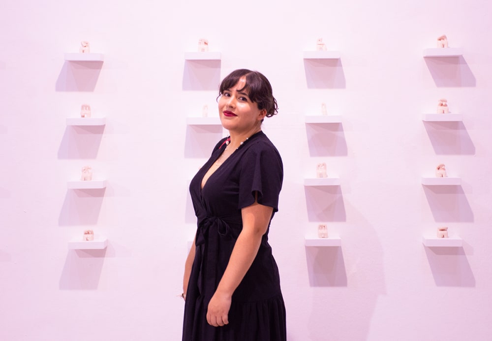 A person stands in front of an exhibition wall.
