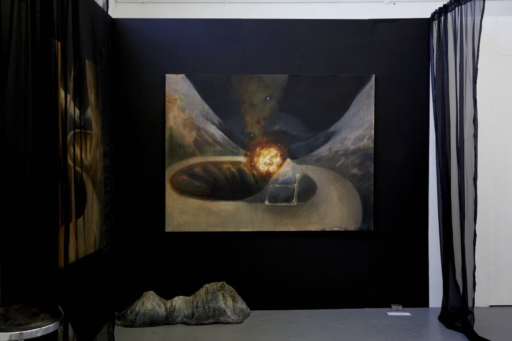 Image shows a black wall with a painting in the middle. The painting has a ‘outer space’ theme to it and a curtain can be seen the right of the shot.