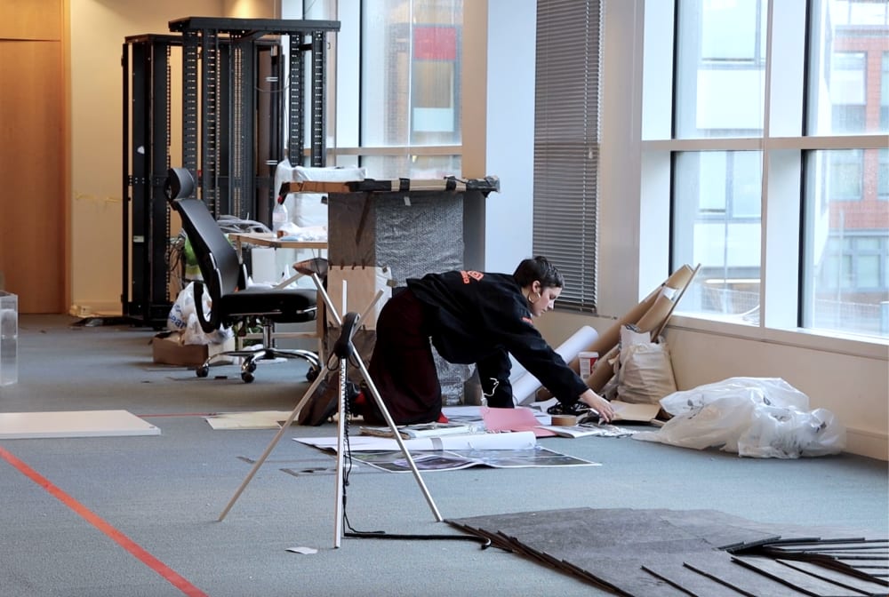 Serena sitting on the floor working on an installation
