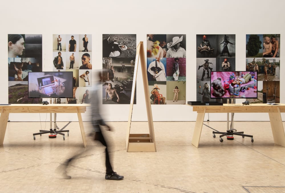A person walking past an exhibition of fashion imagery and publications. They are blurred in motion.