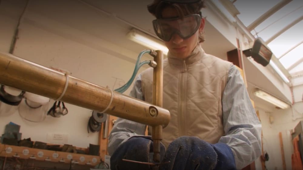 Student on machine in metal workshop