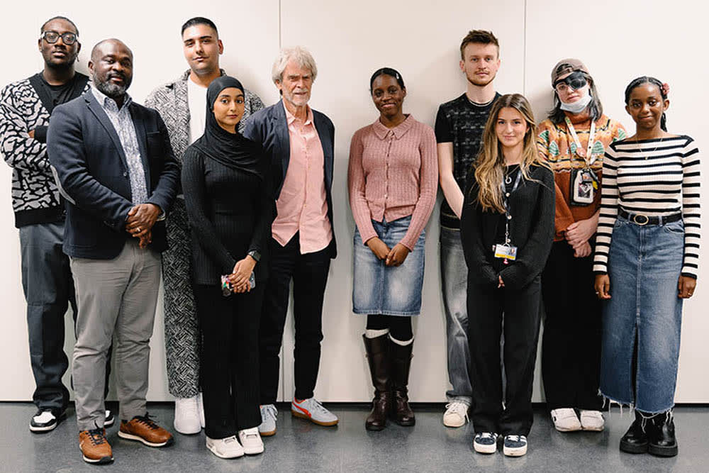 A group of studentsd stand together with an older man from the Hegarty foundation. They are smiling and looking at the camera.