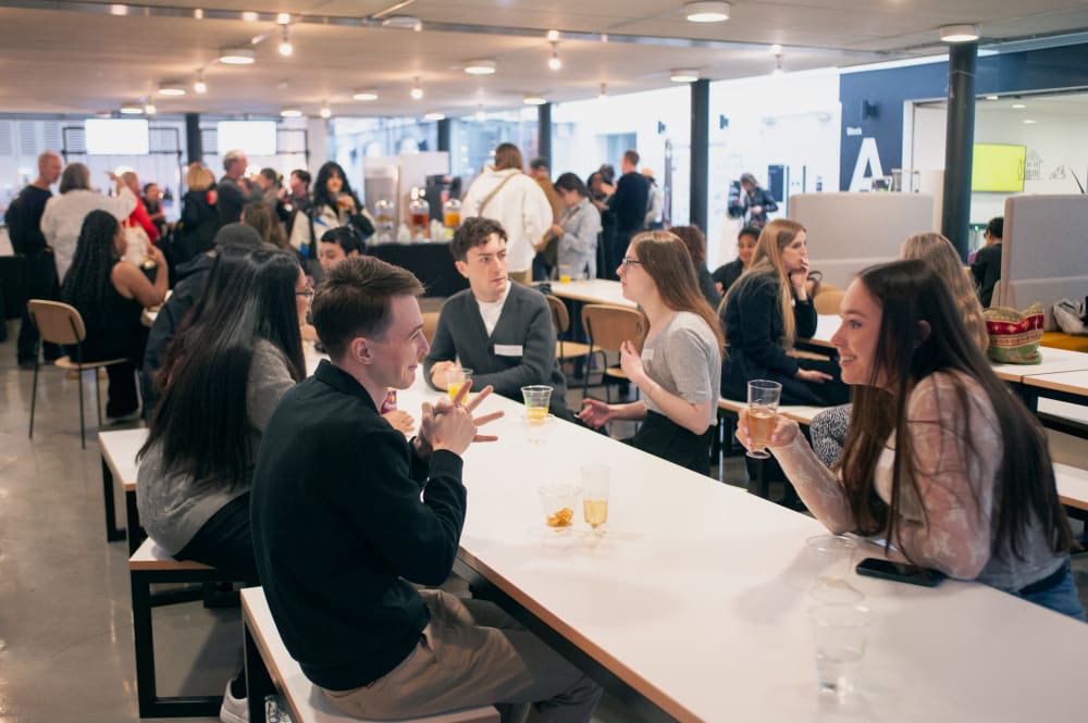 Guest sat at long tables chatting during the event.