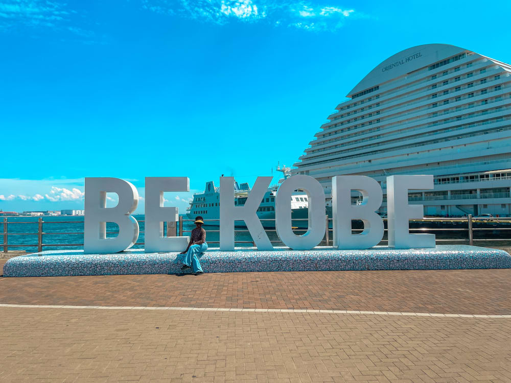 a photo of a student sat on a sign that says be kobe