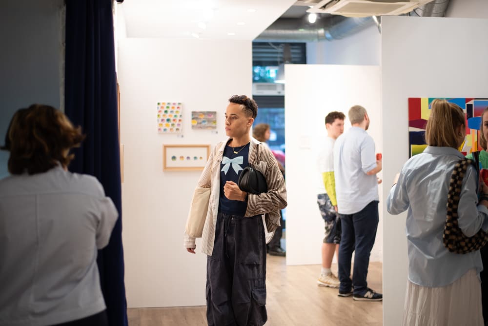 Visitors to the gallery, walking around the space. 