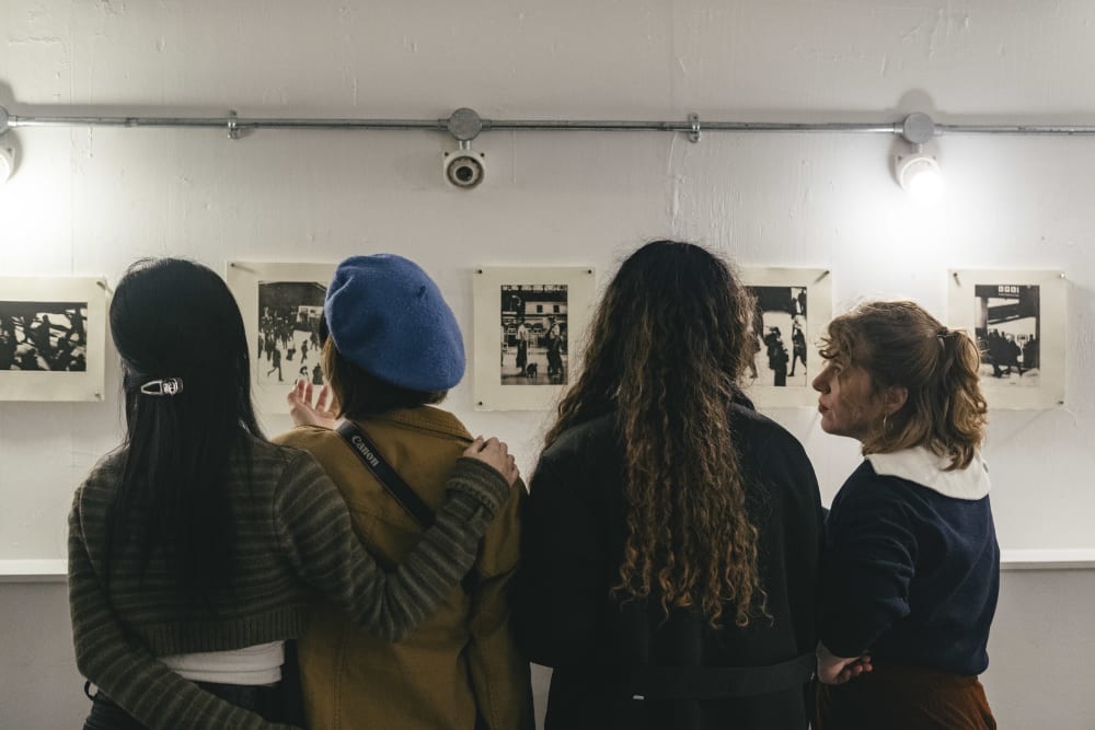 people from behind looking at wall art