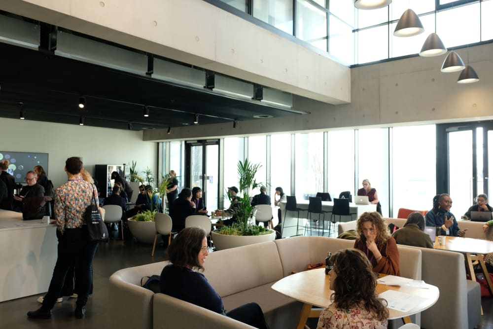 People sat in a lounge at a university and talking to each other.