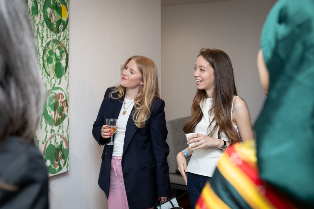 Zeina and a guest looking at her work