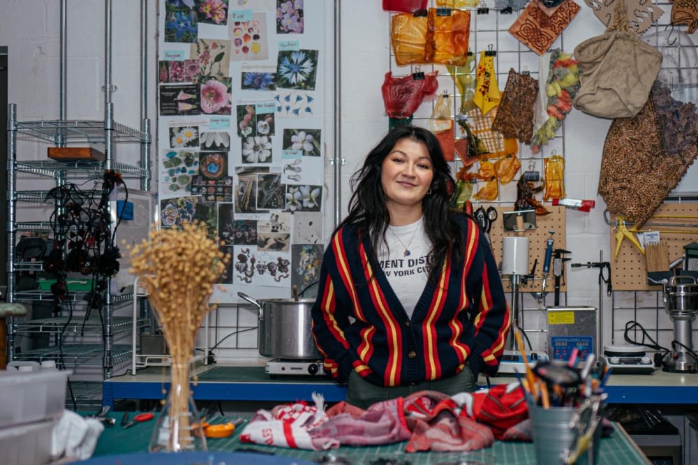 photo of student at a table covered in colourful crafts