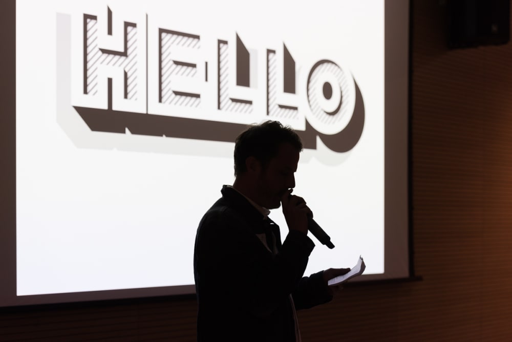 Silhouette of somebody speaking into a microphone