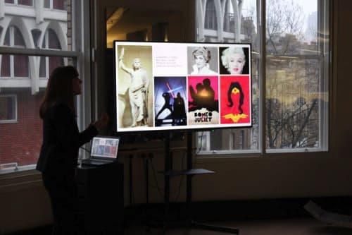 Woman presenting in front of a large screen