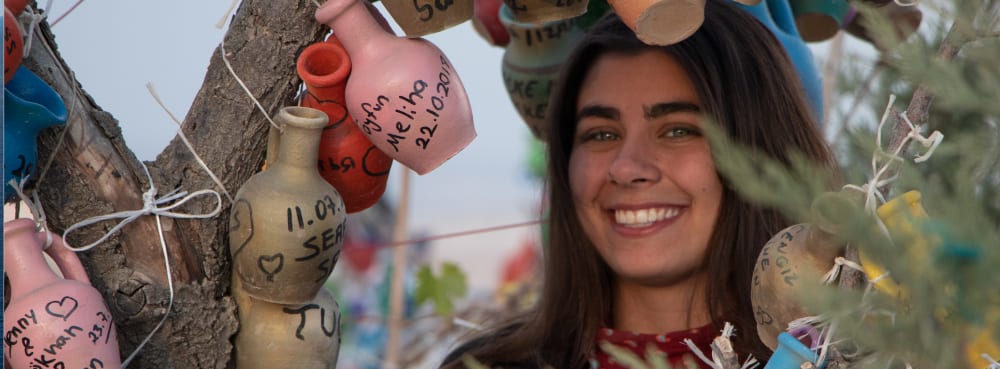 Smiling young person among Christmas tree baubles