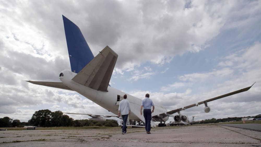 Photo of a plane with 2 people walking towards it
