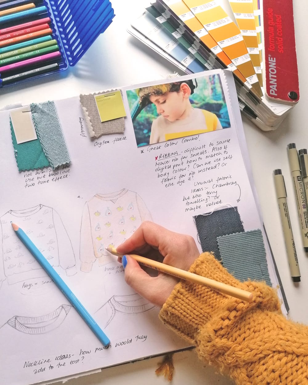 A sketch pad with swatches of material samples and notes