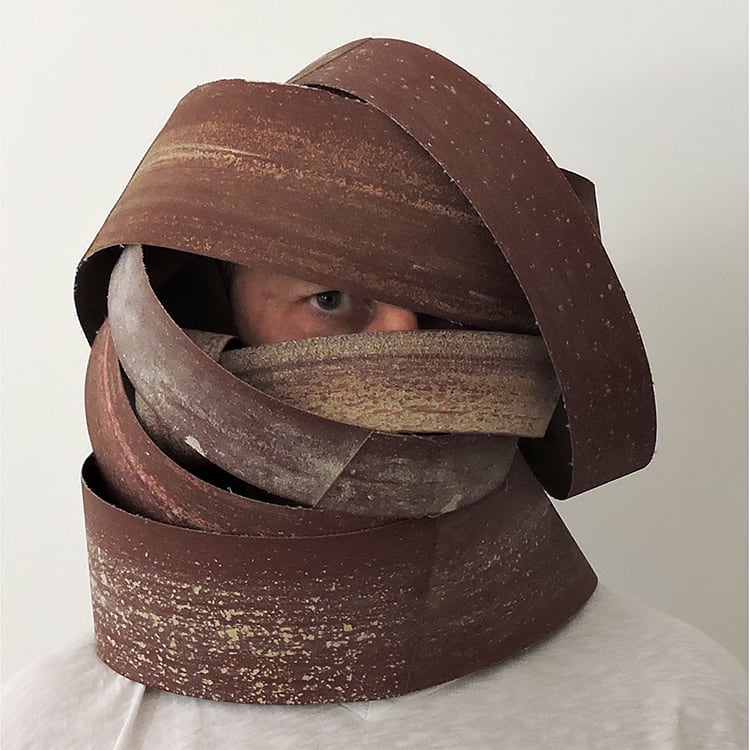 a man's head wrapped in brown paper strips