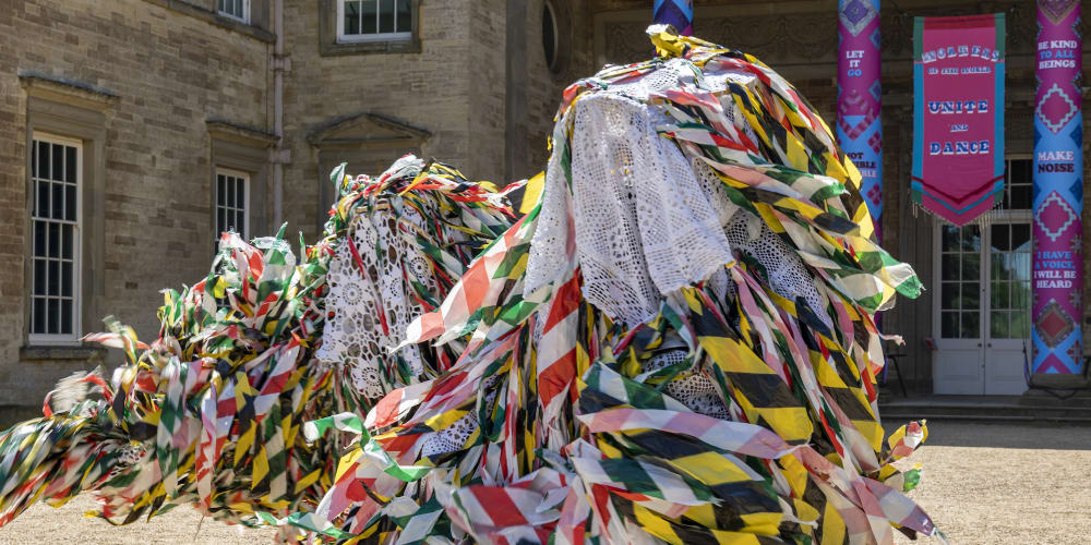 Dynamic photograph of a person dancing in a flowing and colourful folk outfit.