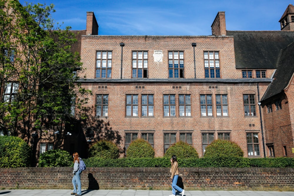 The exterior of UAL Pre-degree studies, a redish brown brick building surrounded by greenery