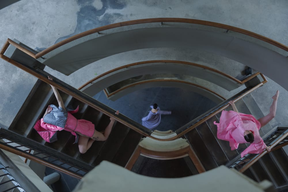 Still of staircase and 3 costumes created by Jovana Gospavic MA Costume for Performance