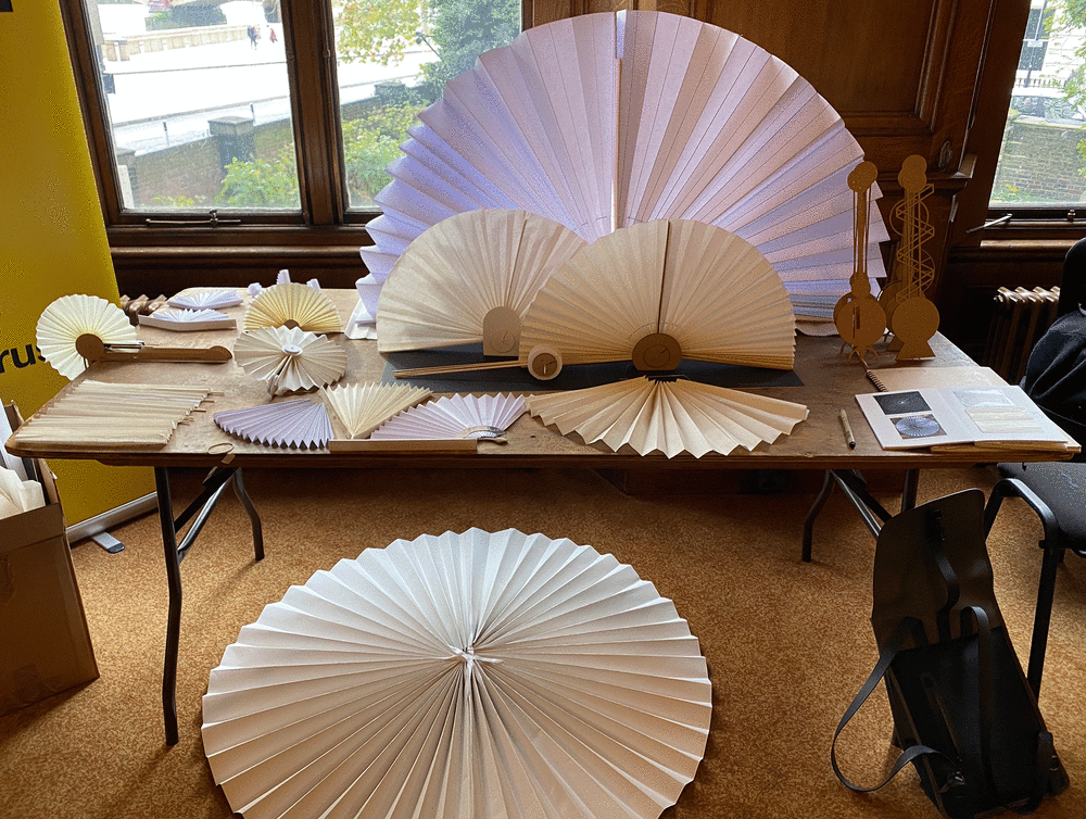 A range of different size fans made from white paper