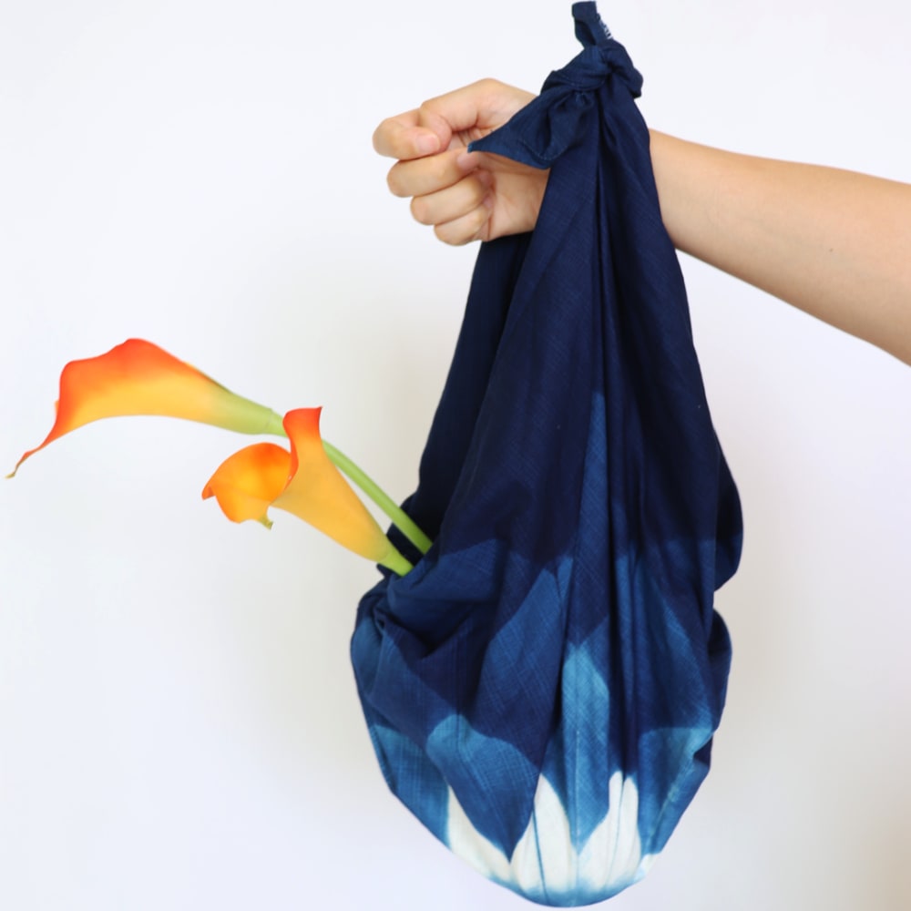  image of the furoshiki converting into a bag to show its functional versatility  