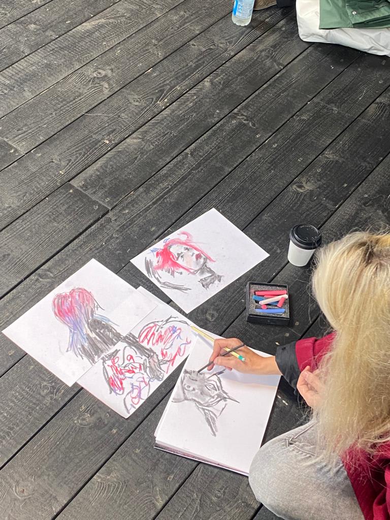 student sat on the ground illustrating a woman