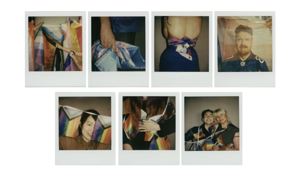 A wall of polaroids, showing different members of the UAL LGBTQ+ community.
