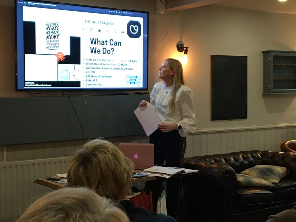 Heather presenting with a powerpoint presentation. On the screen it says ' What Can We Do?'