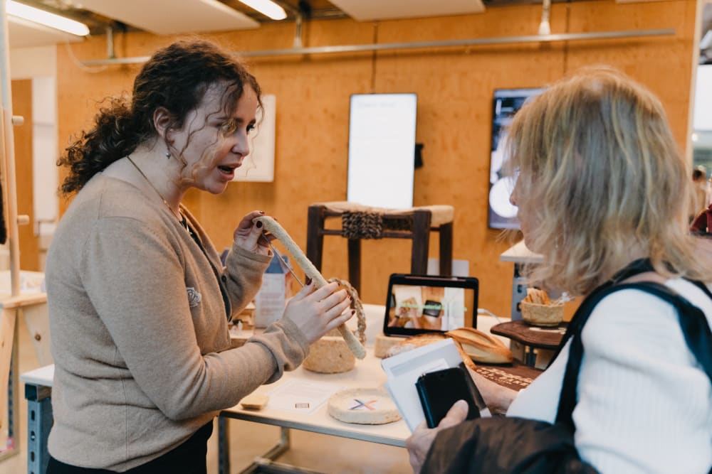 Guests looking at work on display. 2 women talking about the work. 