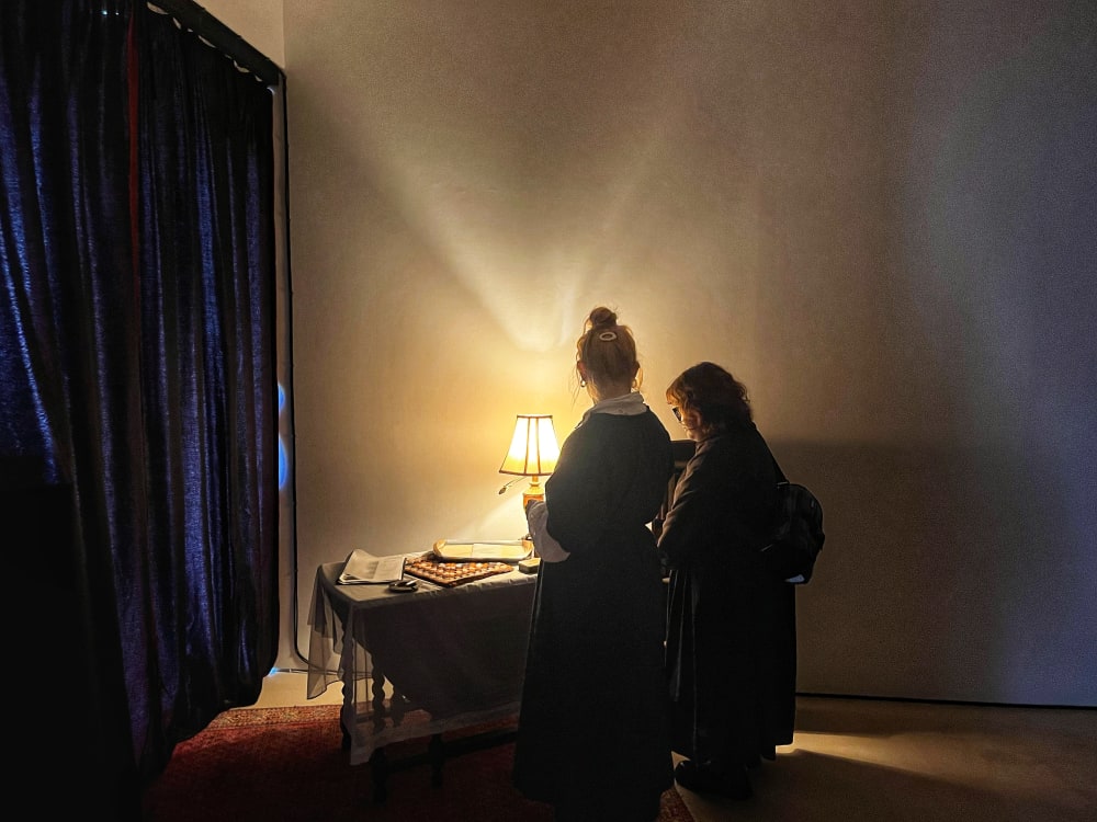 the silhouette of two people looking at a table