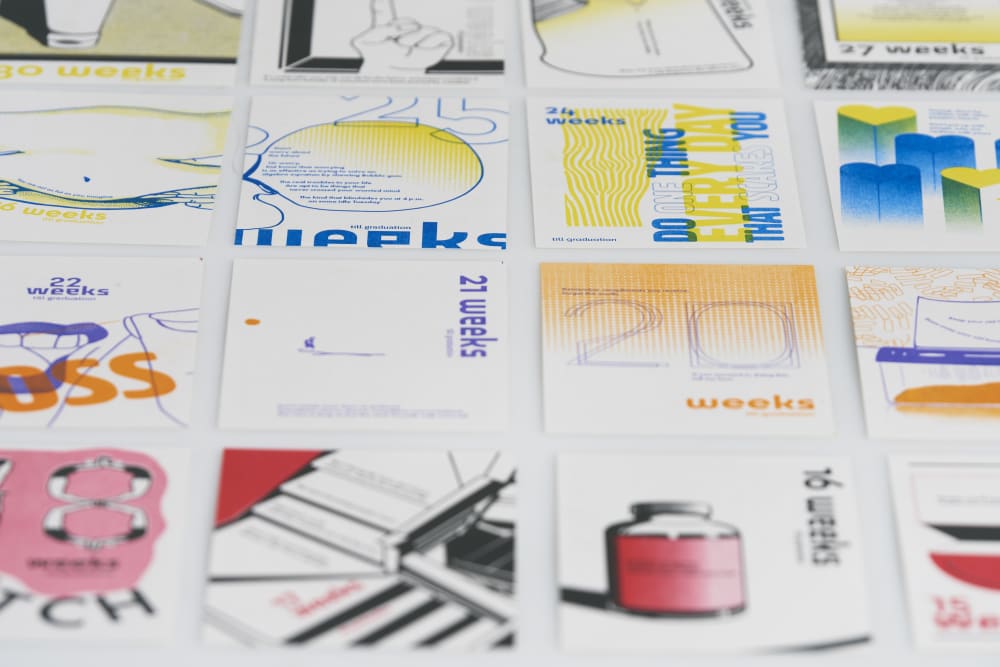A collection of visually diverse, creatively designed posters arranged in a grid, each labeled with a specific number of weeks remaining until graduation.