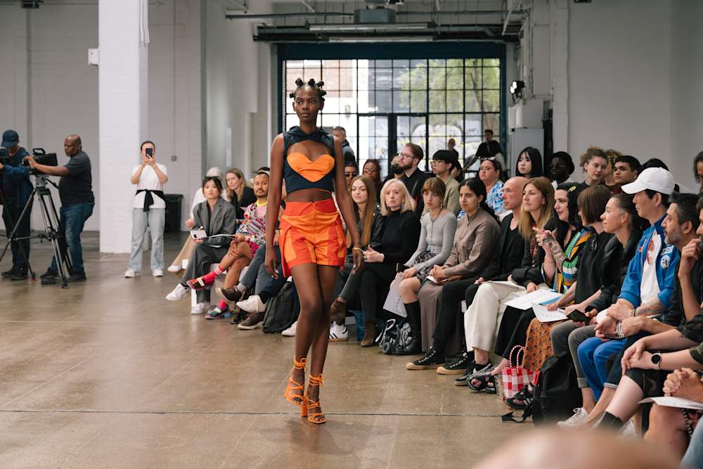 Model showcasing a custom fashion design on the catwalk at London College of Fashion