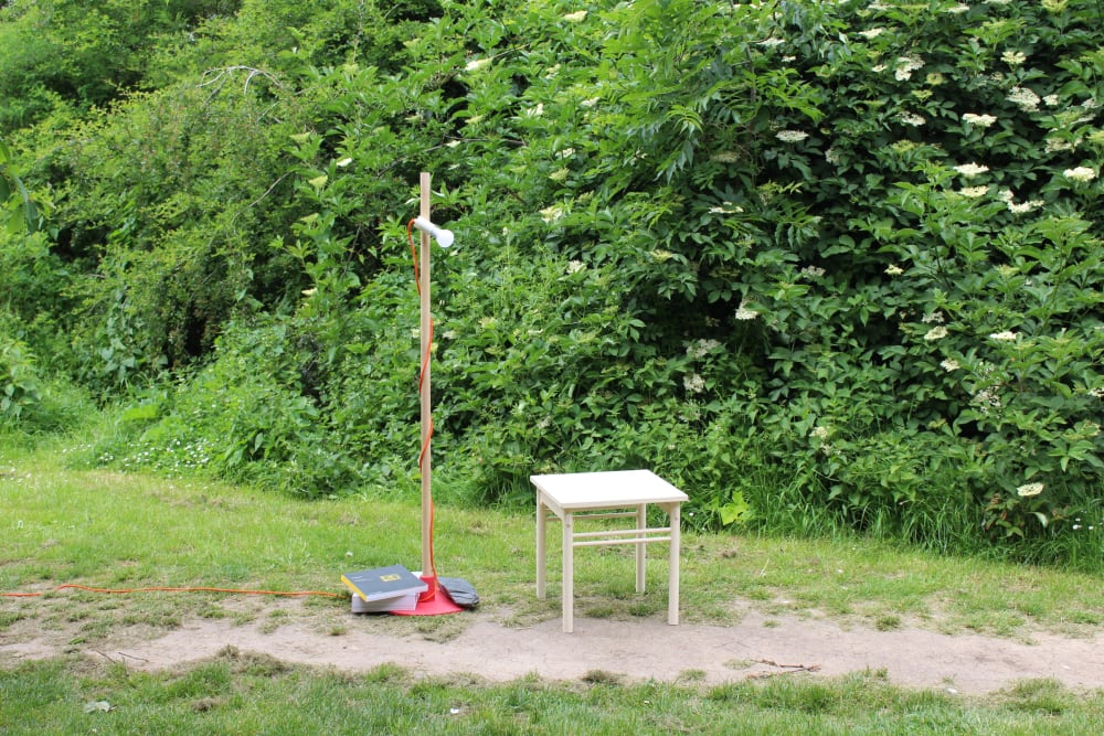 A wooden table and lamp shot against nature