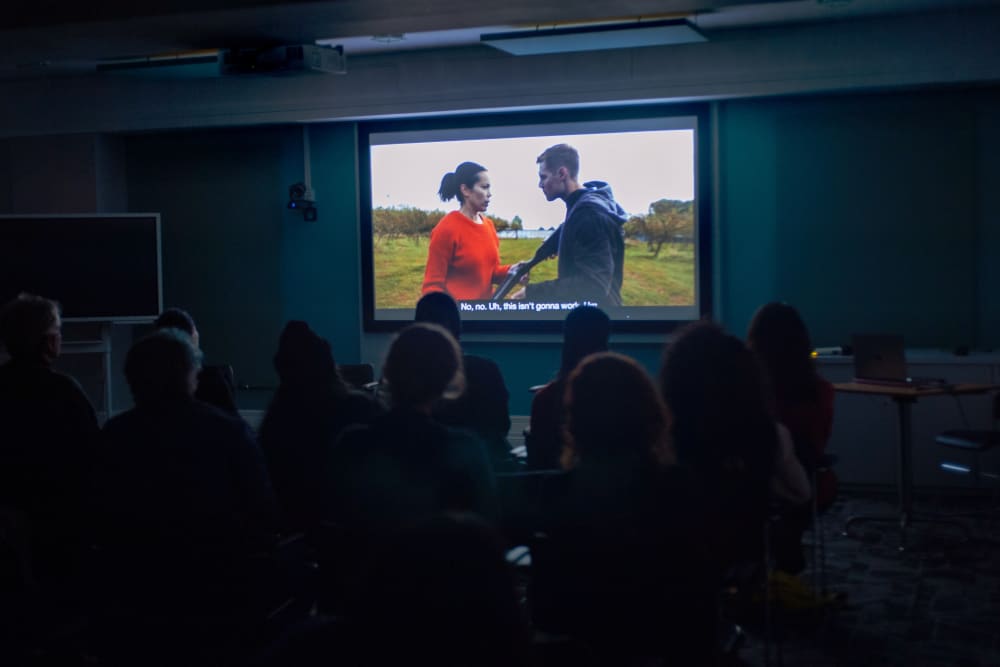 freeze frame from an alumni video played at the AoCA screening event