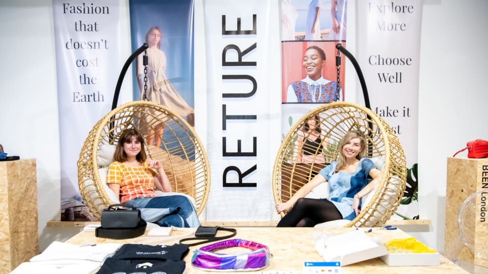 Two women sitting in wicket rockers at a pop-up shop event.