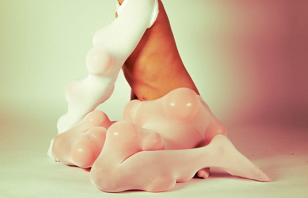 Photograph of someone wearing conceptual textiles filled with balloons.