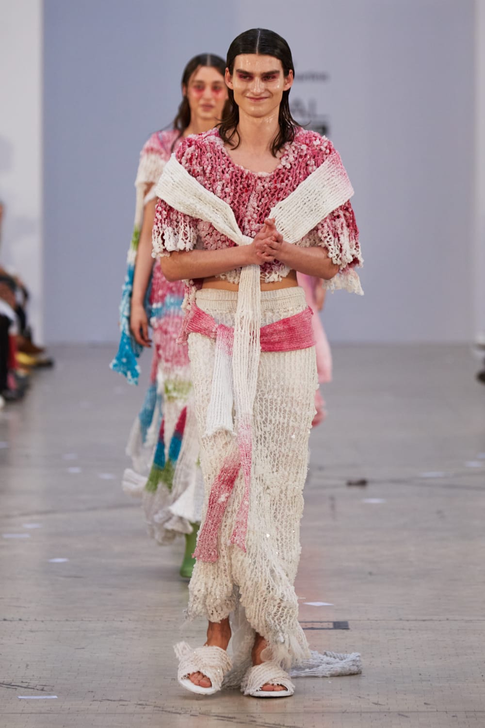 A model on the catwalk in a pink and white crystal beaded knit garment