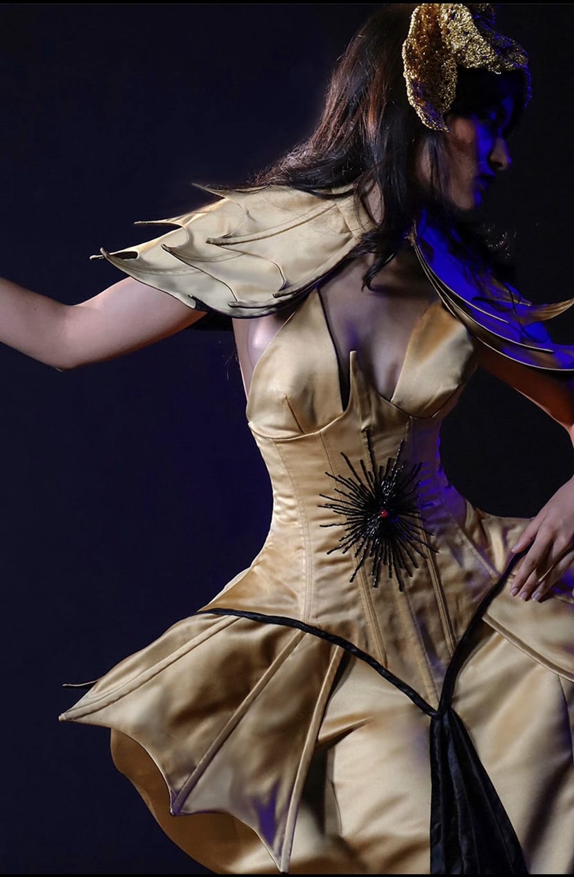 The Mind, gold costume with corset and shoulder pads
