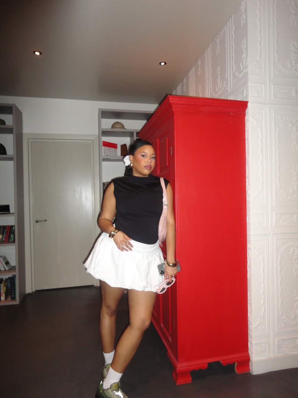 Image of a student leaning against a red wardrobe