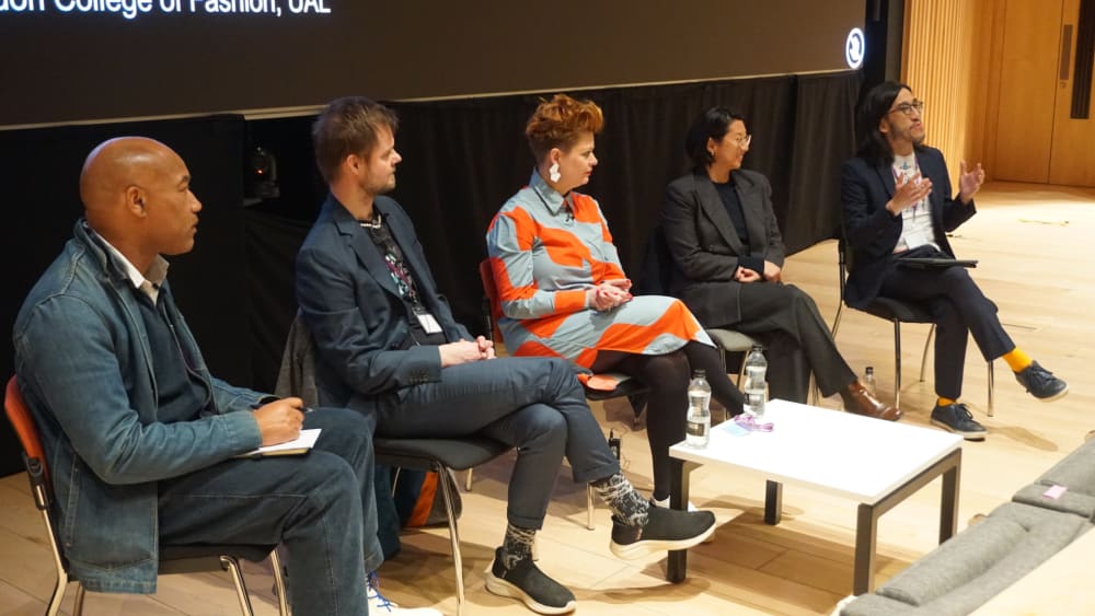 Five people sat on chairs in front of a lecture theatre for a panel discussion.